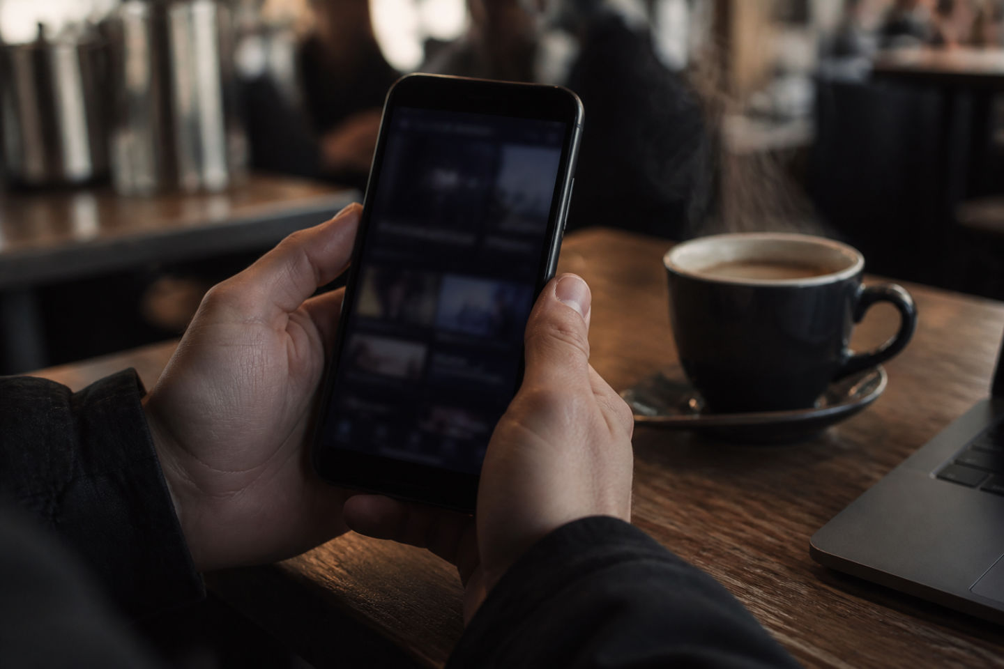 individual using smartphone in a coffee shop